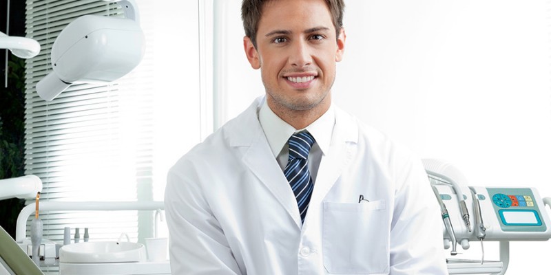 Happy Male Dentist In Clinic